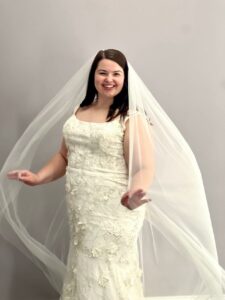 Plus Size Bride to Be from Baldwinsville, NY posing in her wedding gown and veil from Mirror Mirror Bridal Boutique.