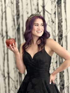 Stunning Bride to Be wearing her black gothic wedding dress and gothic tiara while holding a rhinestone, red apple.