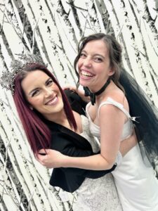 Two Brides from Baldwinsville, NY hugging and laughing together in their wedding gowns.