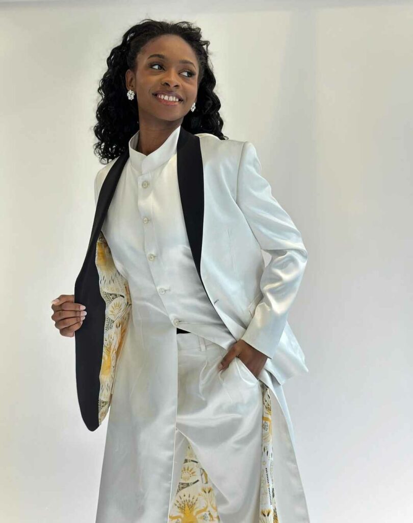 Stunning Bride to be posing in her white tuxedo dress with yellow lining and black lapels.